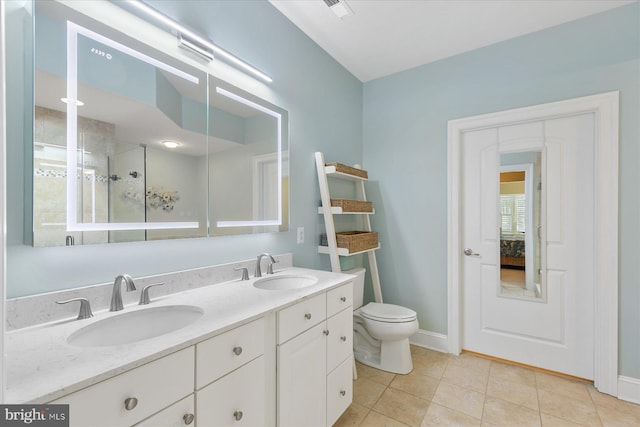 bathroom with vanity, tile patterned floors, toilet, and walk in shower