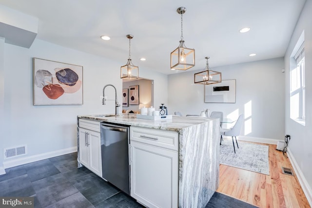 kitchen with hanging light fixtures, dishwasher, a kitchen island with sink, and white cabinets