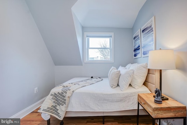 bedroom with lofted ceiling and hardwood / wood-style floors