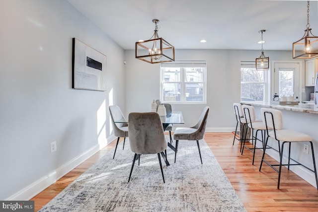 dining space with an inviting chandelier and light wood-type flooring