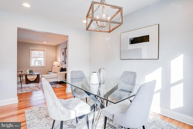 dining area with hardwood / wood-style flooring and a notable chandelier