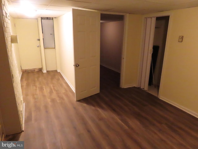 interior space with dark hardwood / wood-style flooring and a drop ceiling