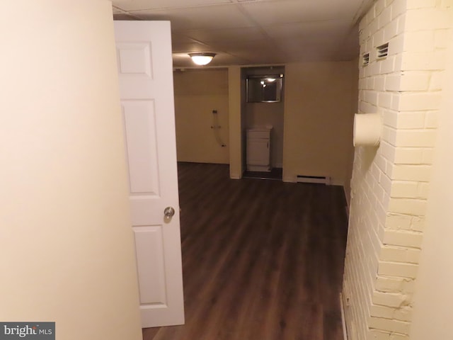 corridor with dark hardwood / wood-style flooring and a baseboard heating unit