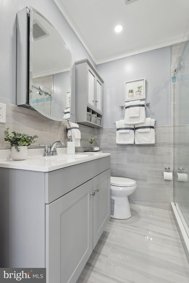 bathroom with vanity, toilet, and a shower with door