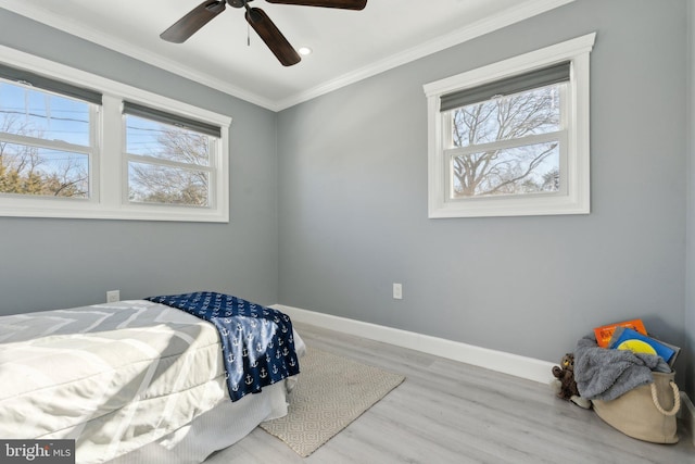 bedroom featuring ceiling fan, light wood-type flooring, ornamental molding, and multiple windows