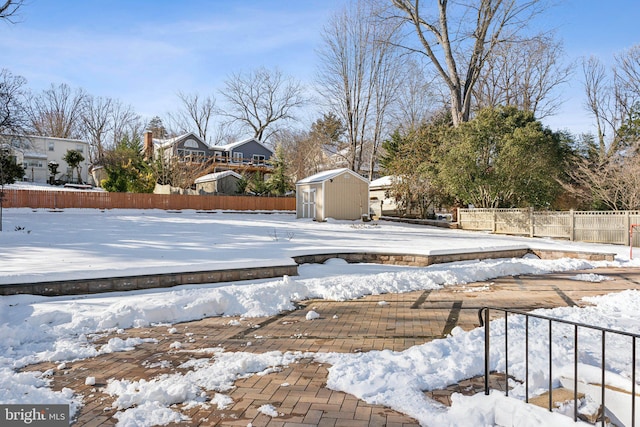 snow covered pool featuring a shed