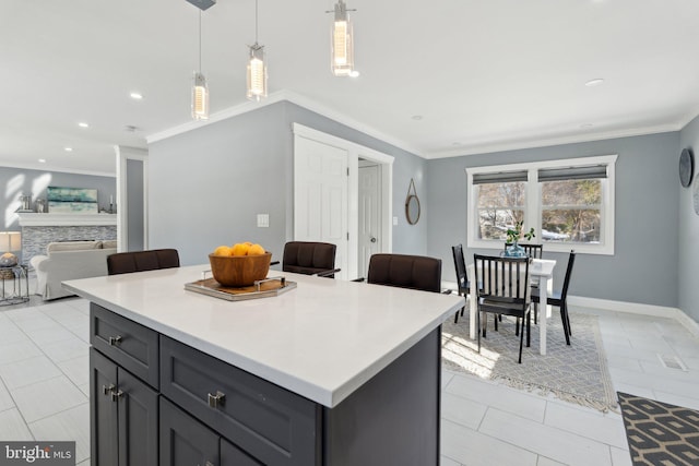 kitchen with light tile patterned floors, gray cabinets, hanging light fixtures, and crown molding