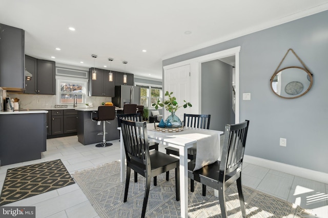 dining space featuring light tile patterned floors and crown molding