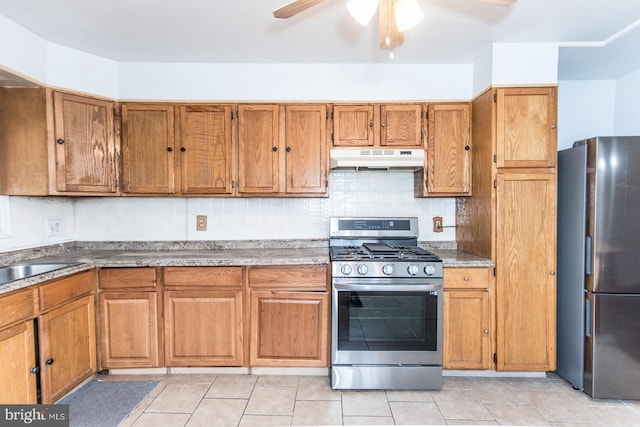 kitchen featuring sink, ceiling fan, light tile patterned floors, tasteful backsplash, and stainless steel appliances