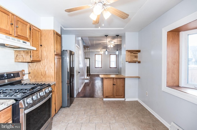 kitchen with ceiling fan, hanging light fixtures, tasteful backsplash, kitchen peninsula, and appliances with stainless steel finishes