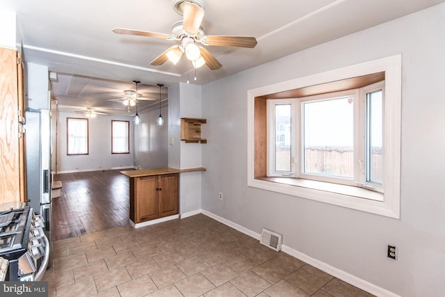 kitchen featuring ceiling fan, kitchen peninsula, and appliances with stainless steel finishes