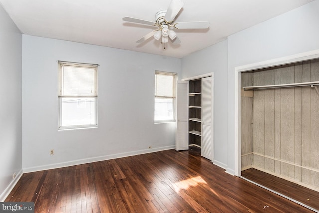 unfurnished bedroom featuring multiple windows, ceiling fan, and dark hardwood / wood-style floors