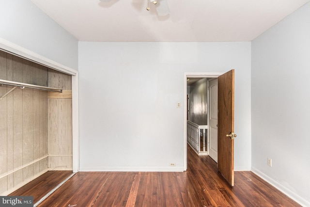 unfurnished bedroom with dark hardwood / wood-style flooring, a closet, and ceiling fan