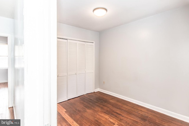 unfurnished bedroom featuring hardwood / wood-style floors and a closet