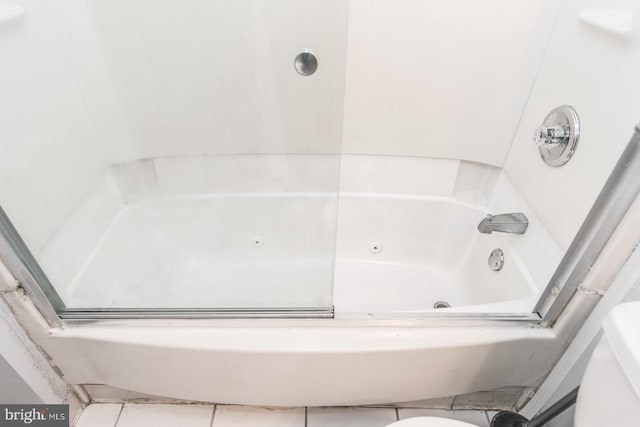 bathroom with tile patterned floors and a bathtub