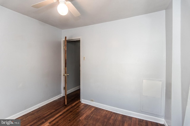 spare room featuring ceiling fan and dark wood-type flooring