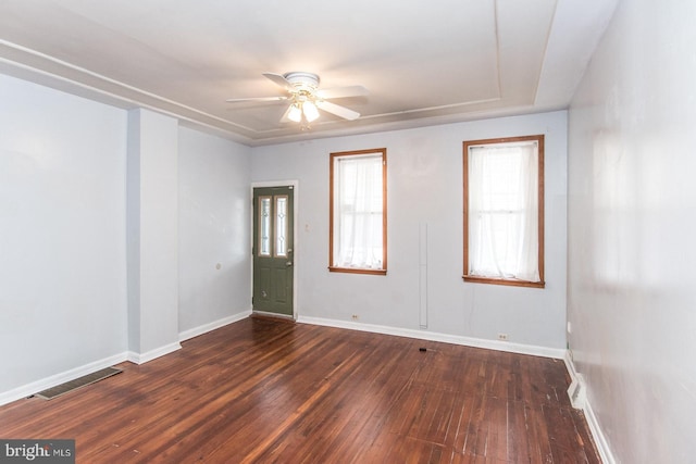 unfurnished room featuring a wealth of natural light, dark hardwood / wood-style floors, and ceiling fan