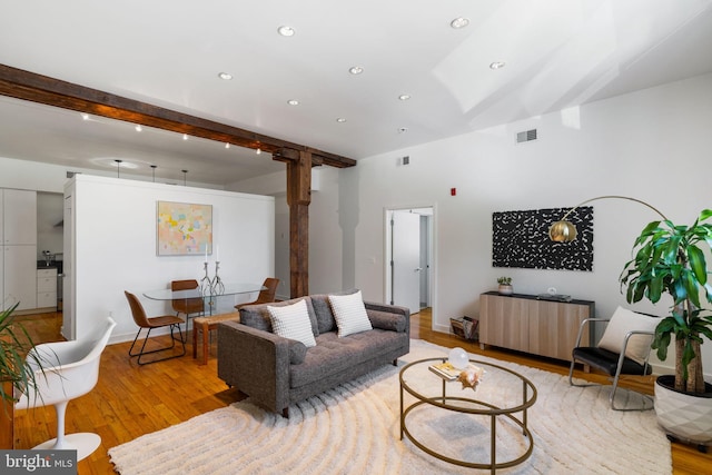 living room featuring light hardwood / wood-style flooring and beamed ceiling