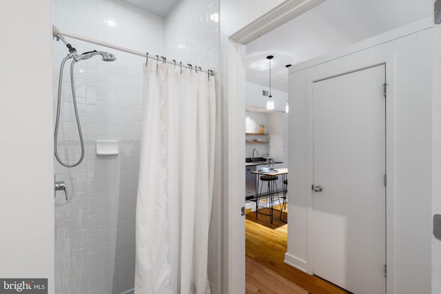 bathroom featuring sink, wood-type flooring, and a shower with shower curtain