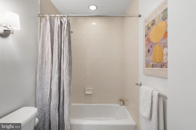 bathroom featuring shower / tub combo and toilet