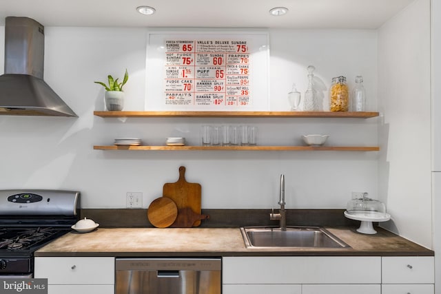 kitchen featuring sink, wall chimney range hood, dishwasher, black gas range, and white cabinetry