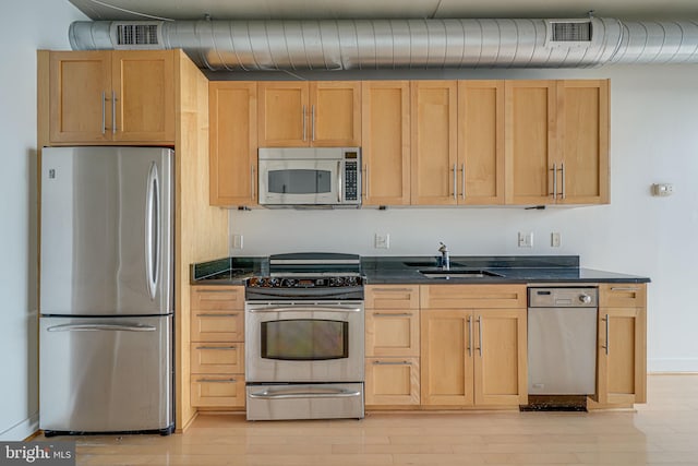 kitchen with light brown cabinetry, sink, light wood-type flooring, and appliances with stainless steel finishes