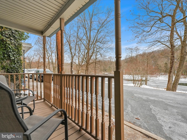 snow covered deck with a porch