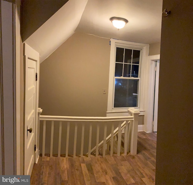 stairs with hardwood / wood-style flooring and lofted ceiling