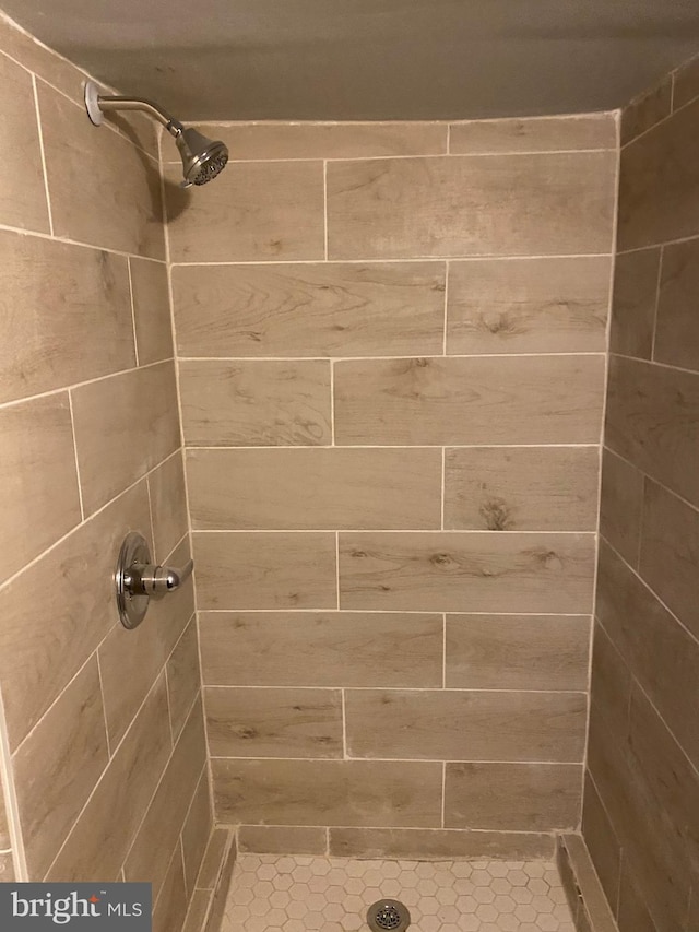 interior details with a tile shower