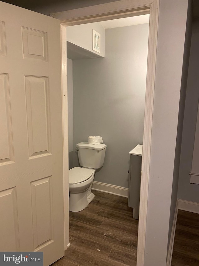 bathroom with hardwood / wood-style floors, vanity, and toilet