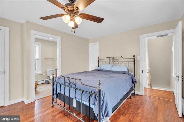 bedroom featuring wood-type flooring, a baseboard radiator, and ceiling fan