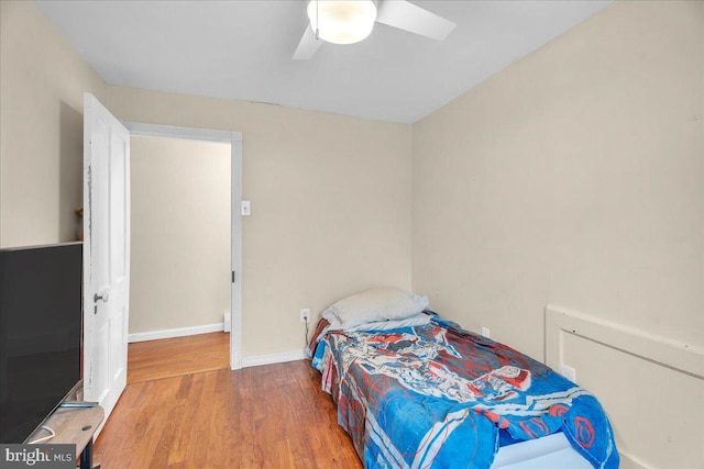 bedroom with a closet, hardwood / wood-style flooring, and ceiling fan