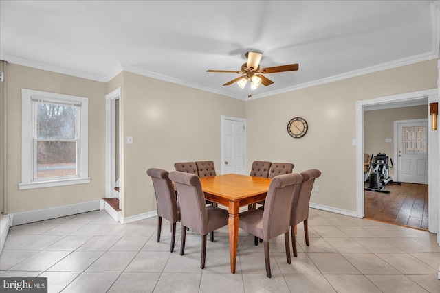 tiled dining space with ceiling fan and ornamental molding