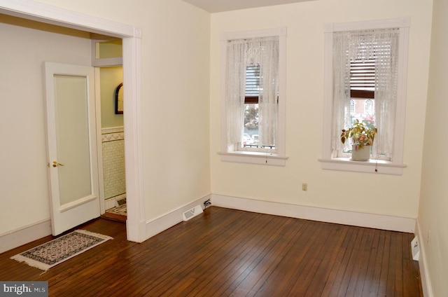 unfurnished room featuring a healthy amount of sunlight and dark hardwood / wood-style floors