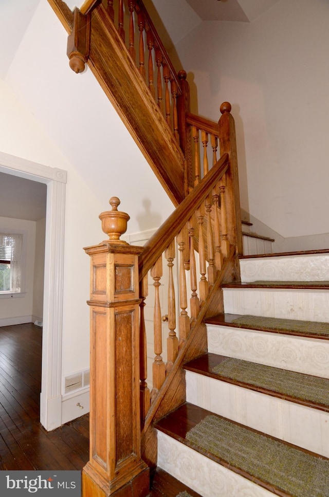 stairway with vaulted ceiling and wood-type flooring