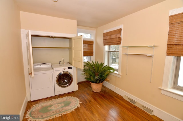 clothes washing area with dark hardwood / wood-style floors and independent washer and dryer