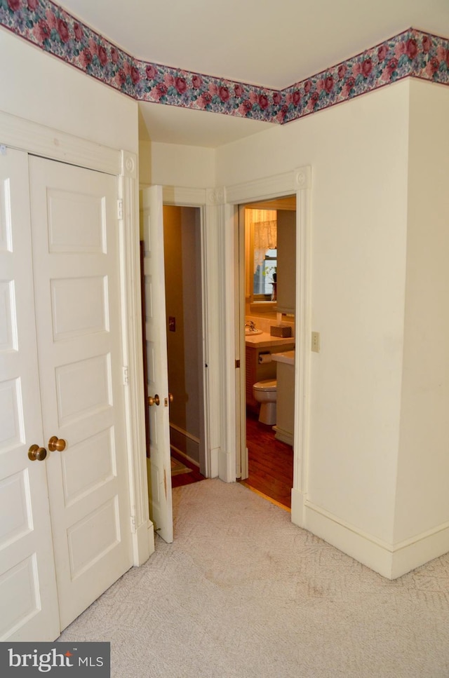 hallway with carpet flooring and sink