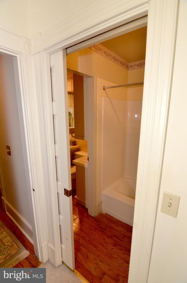 bathroom with hardwood / wood-style flooring and bathtub / shower combination