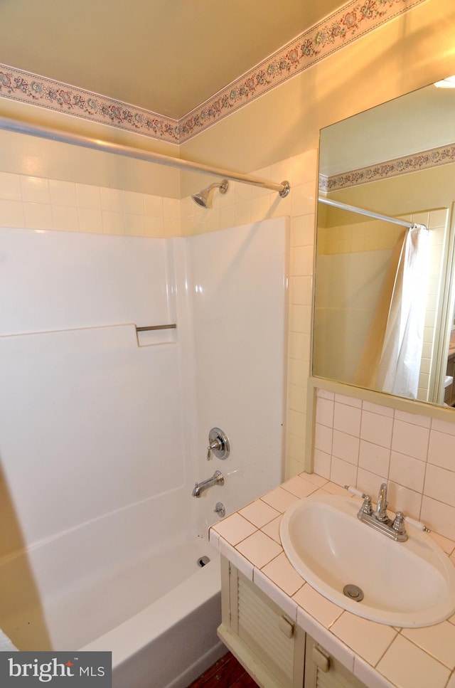 bathroom with shower / tub combo, vanity, and backsplash