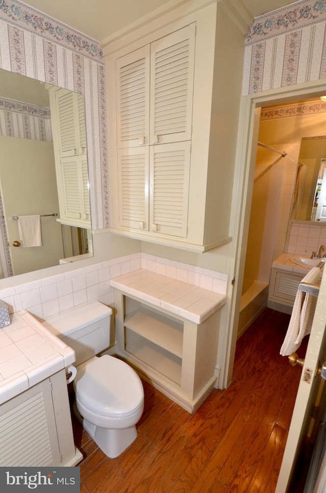 full bathroom with sink, hardwood / wood-style floors, toilet, decorative backsplash, and independent shower and bath