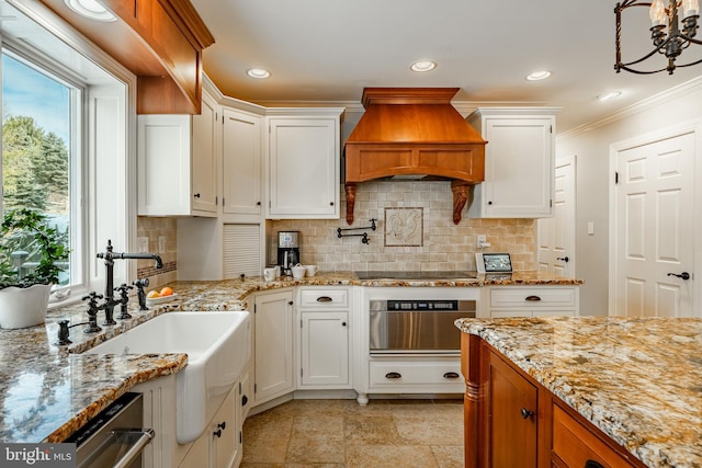 kitchen featuring custom exhaust hood, wall oven, tasteful backsplash, white cabinetry, and sink