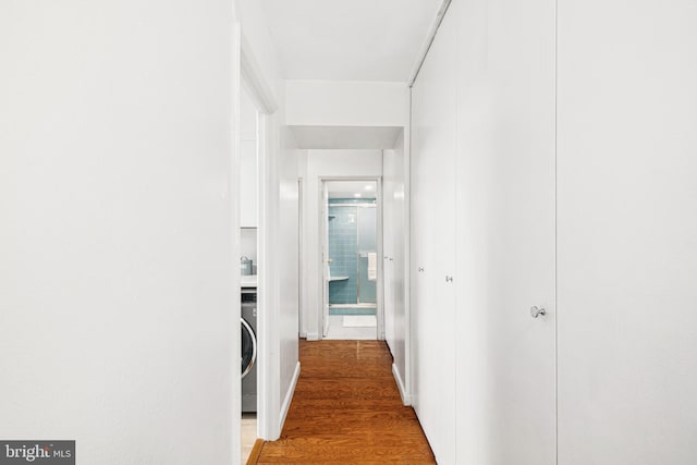 hall featuring hardwood / wood-style floors and washer / dryer