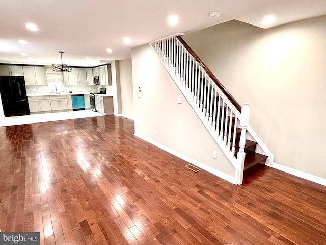 unfurnished living room featuring sink and wood-type flooring