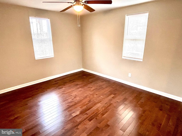 empty room with ceiling fan and dark hardwood / wood-style flooring