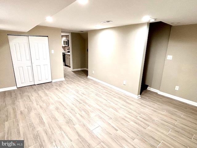 basement with light hardwood / wood-style flooring