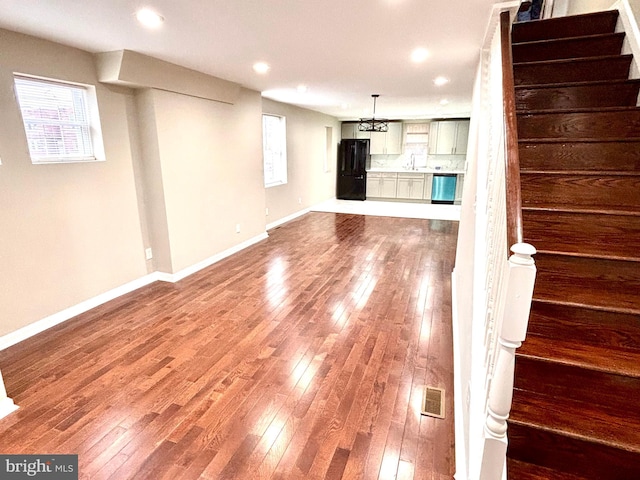 unfurnished living room with sink and hardwood / wood-style flooring