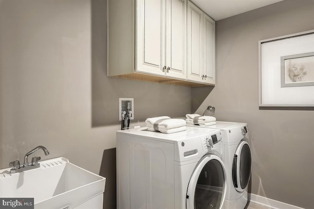 washroom with sink, cabinets, and independent washer and dryer