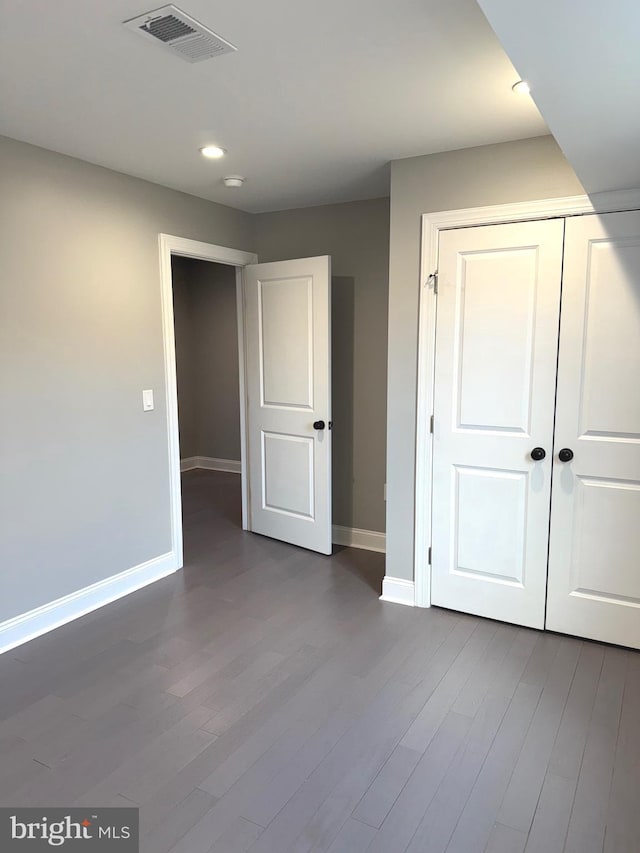 unfurnished bedroom featuring wood-type flooring and a closet