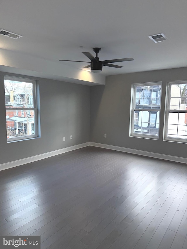 unfurnished room with dark wood-type flooring and ceiling fan