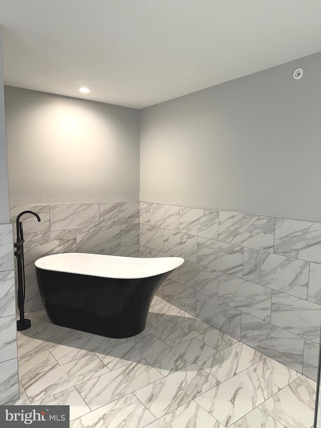 bathroom with a bathtub and tile walls